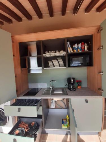 a small kitchen with a sink and a stove at Tenuta Seripa in Sassetta