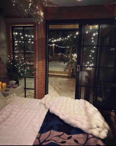 a bed in a room with a window with lights at The Water’s Edge * * Unique Muskoka Treehouse * * in Windermere
