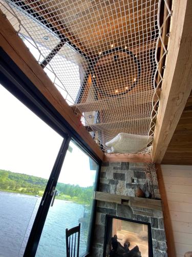 a living room with a view of the water at The Water’s Edge * * Unique Muskoka Treehouse * * in Windermere