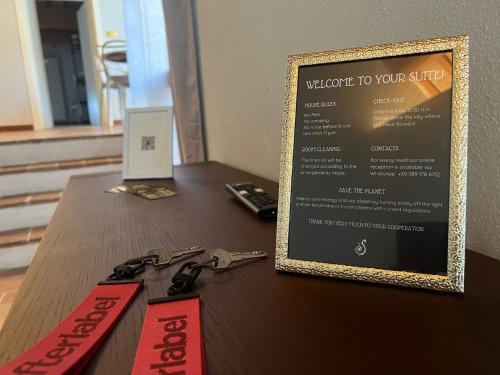 a table with a sign and some keys on it at Le Suite Di Faenza in Faenza