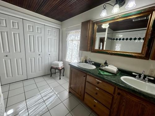Un baño con dos lavabos y un espejo. en Dr Combackers Historic 1880s Home, en Osceola