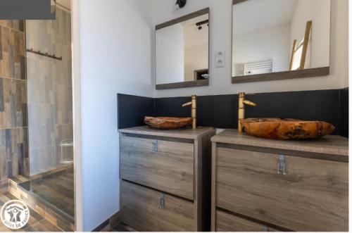 ein Badezimmer mit zwei Holzkommoden und zwei Spiegeln in der Unterkunft Vacances en famille 4 étoiles à 30min des pistes de Ski Mont Dore Sancy in Messeix