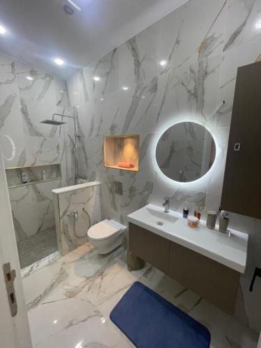 a bathroom with a sink and a toilet and a mirror at Charmante maison de ville in Bin Rhilouf