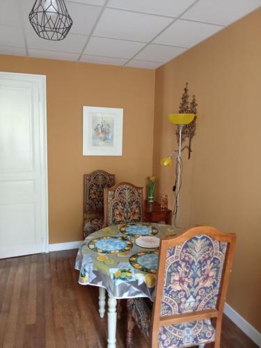 une salle à manger avec une table et deux chaises dans l'établissement Appartement Les fleurs du parc classé 3 étoiles, à Vittel