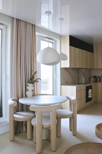 jadalnia z białym stołem i krzesłami w obiekcie Centaurus Olsztyn Sunset Apartament - Dwa Balkony & Darmowy Parking podziemny & Stare Miasto & Galeria & Widok & Planetarium & Centrum miasta w Olsztynie