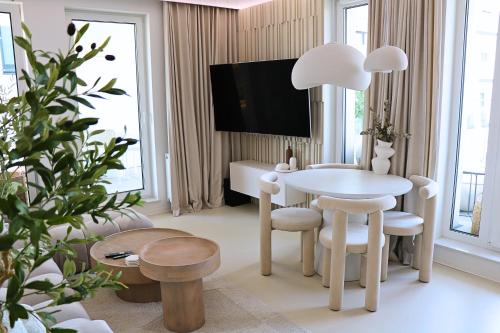 salon z białym stołem i krzesłami w obiekcie Centaurus Olsztyn Sunset Apartament - Dwa Balkony & Darmowy Parking podziemny & Stare Miasto & Galeria & Widok & Planetarium & Centrum miasta w Olsztynie