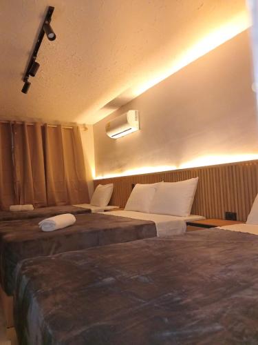 a hotel room with two beds and two chairs at HOTEl CAFE BOUTIQUE in Pereira