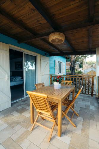 a wooden table and chairs on a patio at Les Ti Kaz d'Auguste in Les Avirons