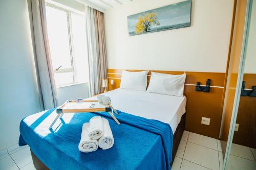 ein Hotelzimmer mit einem Bett mit Handtüchern darauf in der Unterkunft OZPED Flats Particulares Edifício Premier in Brasilia