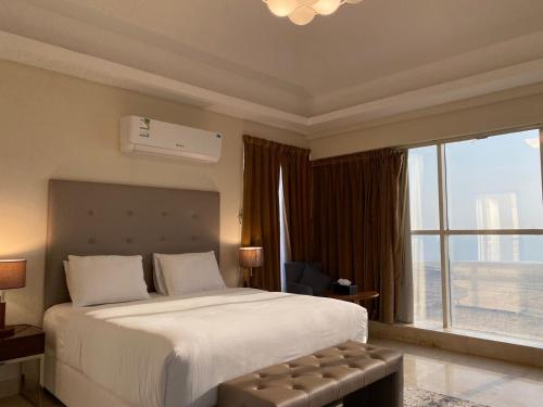 a bedroom with a large bed and a large window at كورت للشقق المخدومة in Al Khobar