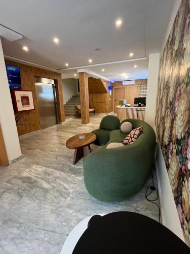 a living room with a green couch and a table at Hôtel Everest, Séjour Balnéaire à Saïdia in Saidia 