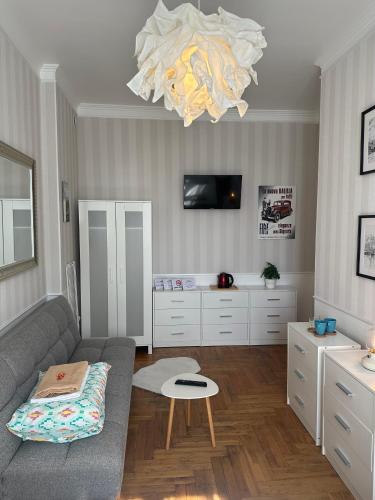 a living room with a couch and a chandelier at Happy8 in Gdynia