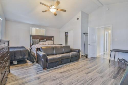 a bedroom with a couch and a bed with a ceiling fan at Lovely Private Bedroom Near SoFi/USC in Los Angeles