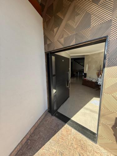 a hallway with a black door and a room at Casa Alto da Serra in Serra Negra
