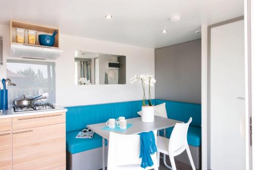 eine Küche mit Tisch und Stühlen in einem Zimmer in der Unterkunft Camping de Maillac in Sainte-Nathalène