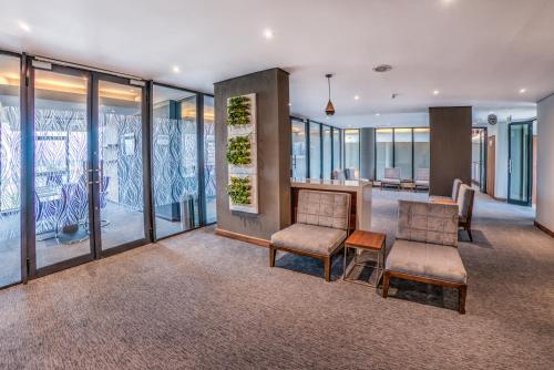 a waiting room with two chairs and windows at City Lodge Hotel Waterfall City in Midrand