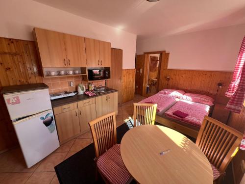 a kitchen with a table and a bed in a room at Apartmány U Švýcarského dvora in Janske Lazne