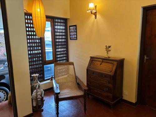 a room with a chair and a dresser and a window at 19 St Stephen's in Sri Jayewardenepura Kotte