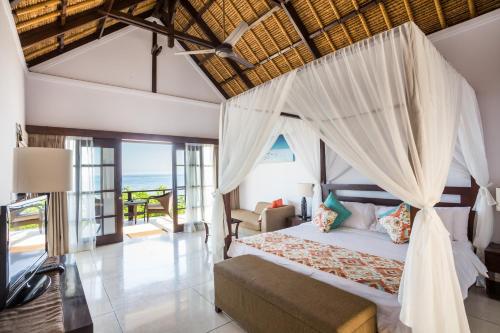 een slaapkamer met een hemelbed bij The Point Resort Lembongan in Nusa Lembongan