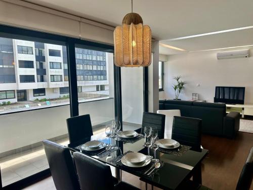 a dining room with a table and chairs and a large window at Azores Pico Salomão T3 - G in Ponta Delgada