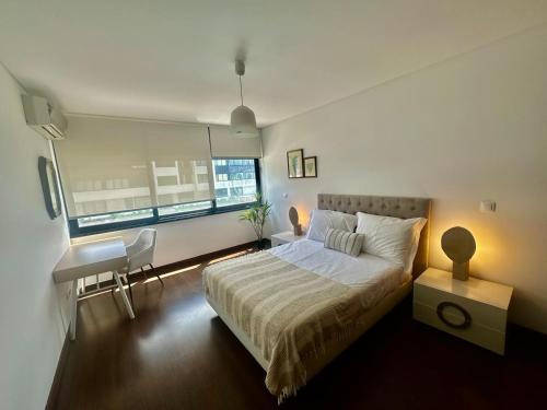 a bedroom with a bed and a desk and a window at Azores Pico Salomão T3 - G in Ponta Delgada