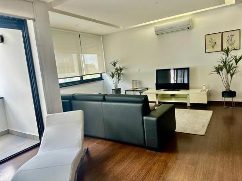a living room with a couch and a tv at Azores Pico Salomão T3 - G in Ponta Delgada