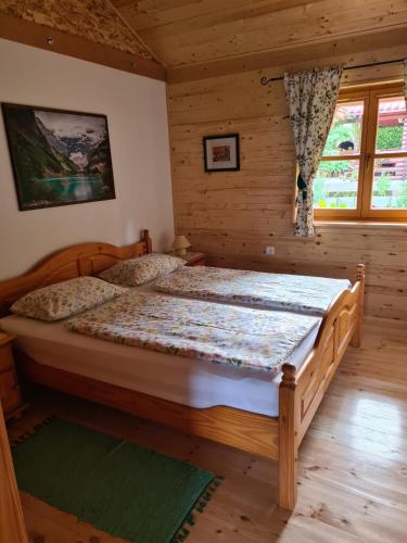 a bedroom with a large bed in a log cabin at Apartment Vila Lokve in Lokve