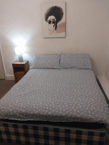 a bedroom with a bed and a night stand with a lamp at Lynwood Hotel & Spa in Blackpool