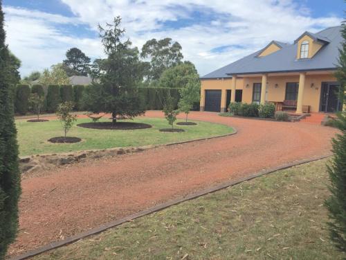 a house with a garden and a driveway at Stately Bowral Designer Home in Bowral
