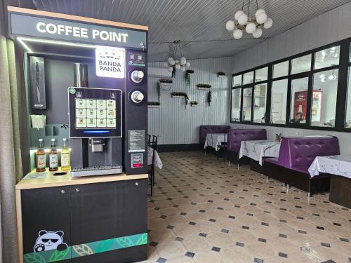KochkorkaにあるSeitek Hotelのテーブルと紫色の椅子が置かれたコーヒーコーナーのあるレストラン