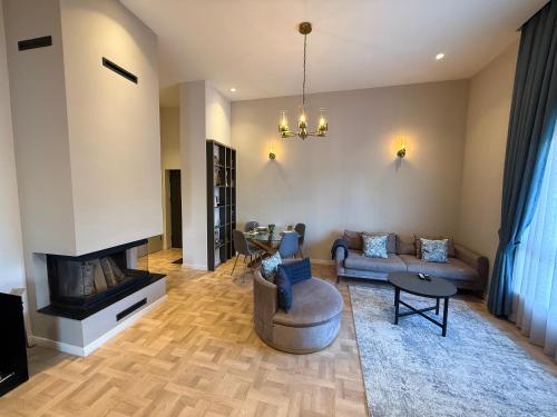 a living room with a couch and a fireplace at Cozy Urban Apartment in Pristina