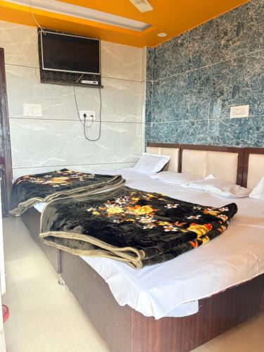 a bedroom with two beds and a tv on the wall at Hotel Shree dhan Laxmi palace in Jāmb