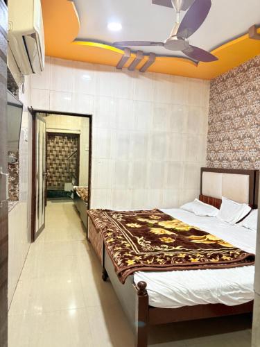 a bedroom with two beds and a ceiling fan at Hotel Shree dhan Laxmi palace in Jāmb
