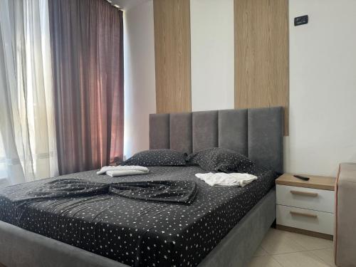 a bedroom with a large bed with a gray headboard at Orkidea Apartments in Golem
