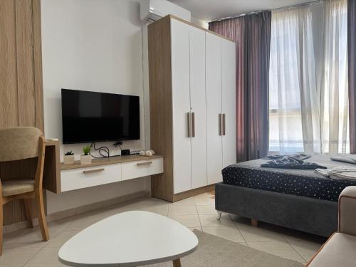 a hotel room with a bed and a tv at Orkidea Apartments in Golem