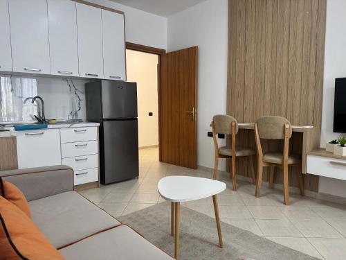 a kitchen with a refrigerator and a table and chairs at Orkidea Apartments in Golem