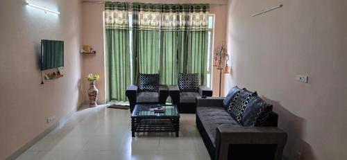 a living room with a couch and chairs and a window at 2BHK kitchen wi-fi Vatika in Gurgaon