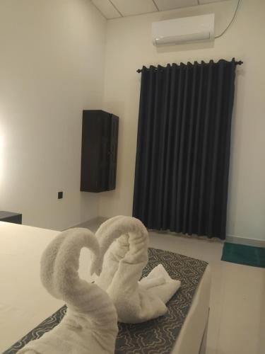 two towel swans sitting on a table in a room at Vimanra Udawalawa in Udawalawe