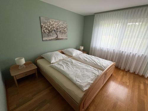 a bedroom with a bed and a window with a tree at Naturblick am Dorfausgang in Rheinau