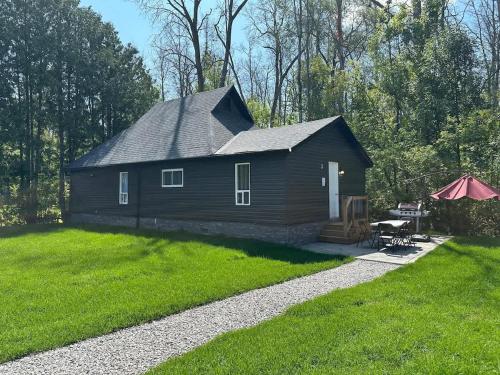 a small black house with a grassy yard at Cozy 4-Bedroom Cottage #3 in Innisfil in Innisfil