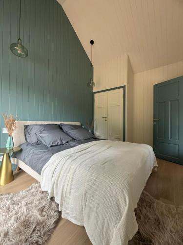 a bedroom with a large bed with a green wall at Kalakuninga Puhkemaja in Liimala