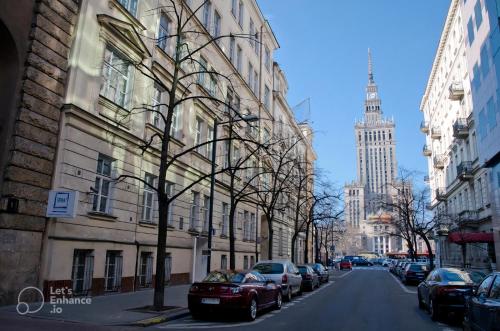 a street with cars parked on the side of a building at Super Central flat with balcony and view of the Palace -50m from MARRIOTT Hotel in Warsaw