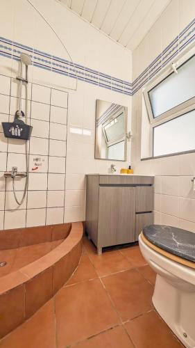 a bathroom with a tub and a sink and a toilet at Loving Strangers Hostel in Madalena