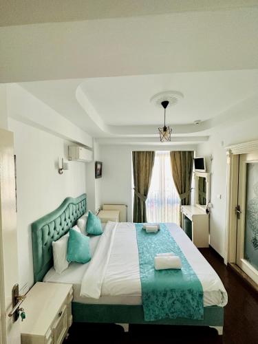 a bedroom with a large bed with blue pillows at LA MAİSON FAMILY Hotel in Istanbul