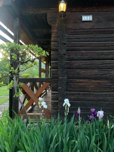 a wooden cabin with flowers in front of it at Stavne 158 in Stavnoye