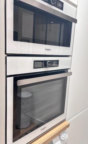a microwave oven sitting on top of a stove at SYLOU - Centre historique, 4 personnes, Climatisation, Netflix, Comédie, Tramway, Gare in Montpellier