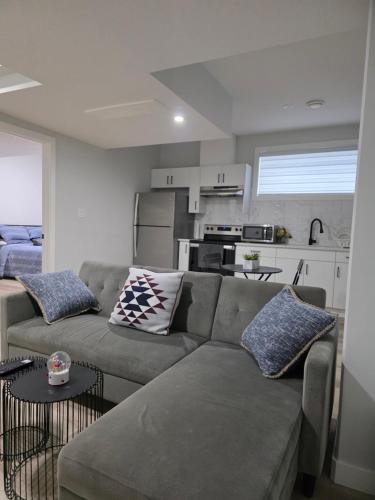 a living room with a couch and a kitchen at Cozy Up in Edmonton
