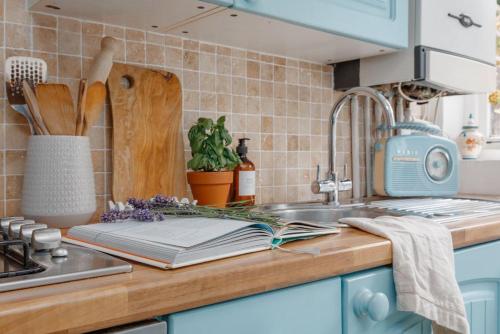 a kitchen counter with a chopping board and a sink at Angel Cottage in Swanage