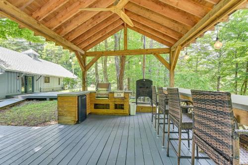 a wooden deck with a kitchen and a stove at Fish and Swim Home with Catskill Creek Views! in East Durham