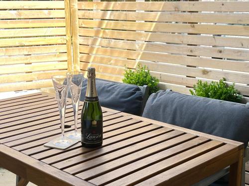 a bottle of champagne and two glasses on a wooden table at Beautiful flat in Harrogate, 2 kingsize beds in Harrogate